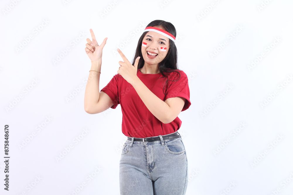 Beautiful young Asian woman pointing aside to copy space and looking at camera and happy Pretty girl act like a satisfied product with celebrate Indonesian independence day on 17 August Beautiful young Asian woman pointing aside to copy space and looking at camera and happy Pretty girl act like a satisfied product with celebrate Indonesian independence day on 17 August