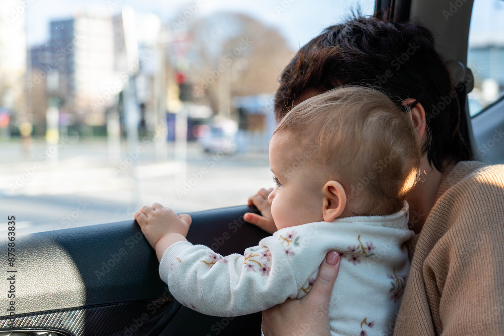 A child in a car looks out the window with interest. Concept of unsafe transportation of children A child in a car looks out the window with interest. Concept of unsafe transportation of children