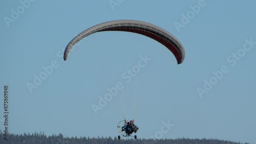 Flight on paraglider with motor and a wing parachute on a summer day photo