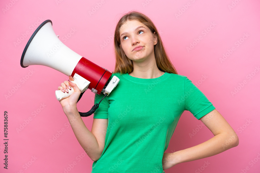 Teenager Russian girl isolated on pink background holding a megaphone and thinking Teenager Russian girl isolated on pink background holding a megaphone and thinking