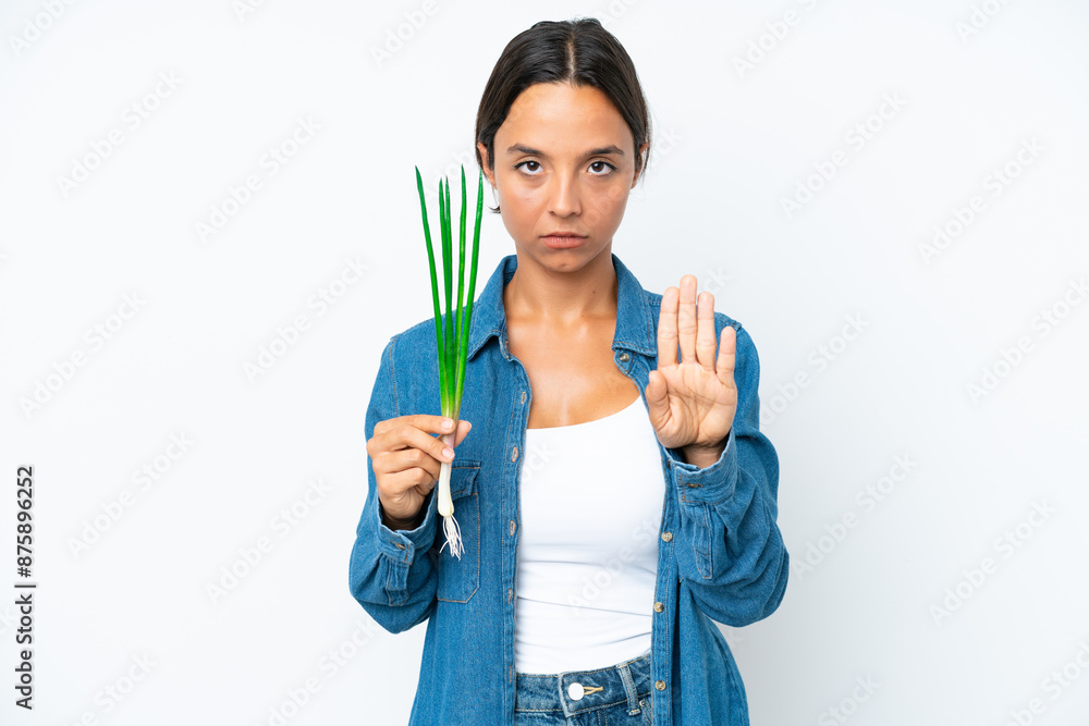 Young hispanic woman holding chive isolated on white background making stop gesture Young hispanic woman holding chive isolated on white background making stop gesture