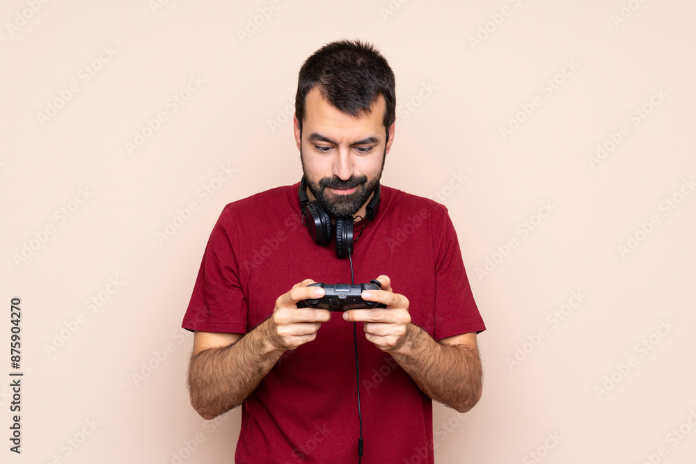Man playing with a video game controller over isolated wall Man playing with a video game controller over isolated wall