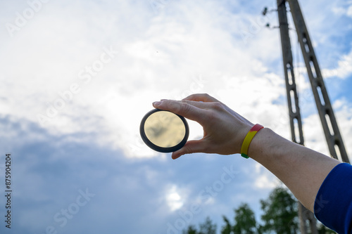 Okrągły filtr szary, ND, polaryzacyjny na tle zachmurzonego nieba  photo