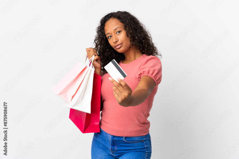 Teenager cuban girl isolated on white background holding shopping bags and a credit card Teenager cuban girl isolated on white background holding shopping bags and a credit card