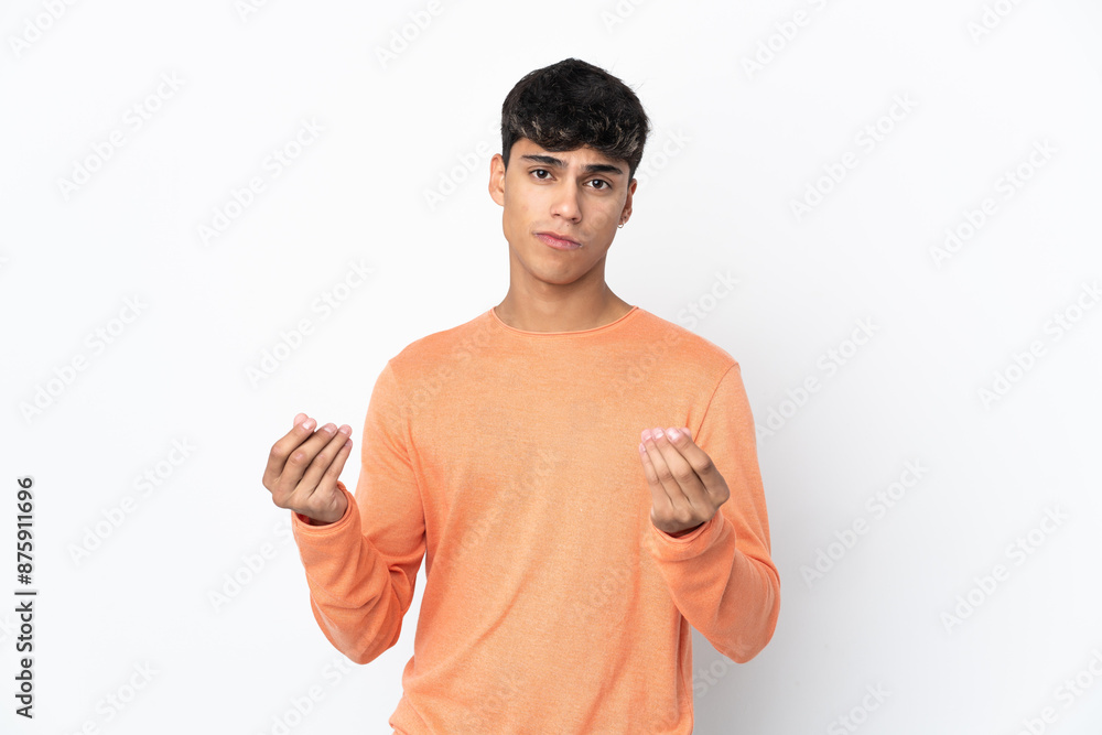 Young man over isolated white background making money gesture but is ruined Young man over isolated white background making money gesture but is ruined