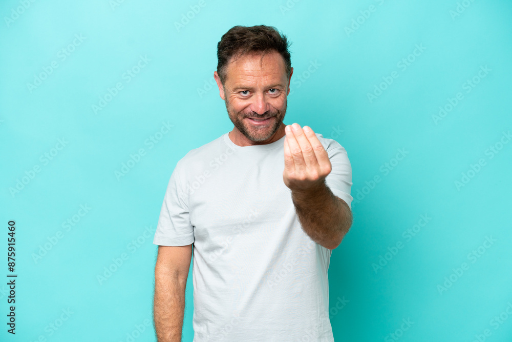 Middle age caucasian man isolated on blue background inviting to come with hand. Happy that you came Middle age caucasian man isolated on blue background inviting to come with hand. Happy that you came