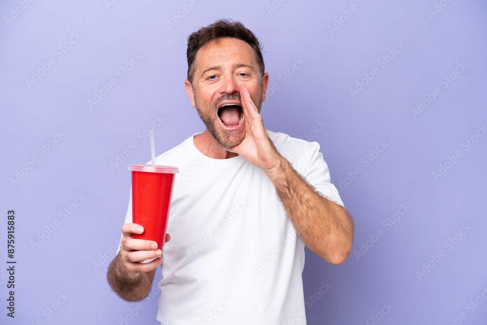 Middle age caucasian man holding soda isolated on purple background shouting with mouth wide open Middle age caucasian man holding soda isolated on purple background shouting with mouth wide open