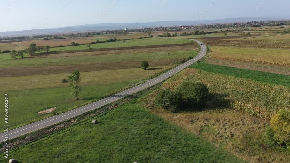 Car driving on a countryside road among agriculture fields. Aerial drone view Car driving on a countryside road among agriculture fields. Aerial drone view