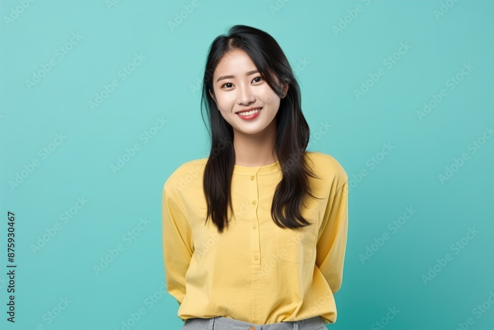 Fototapeta premium A woman in a yellow shirt is smiling and posing for a picture