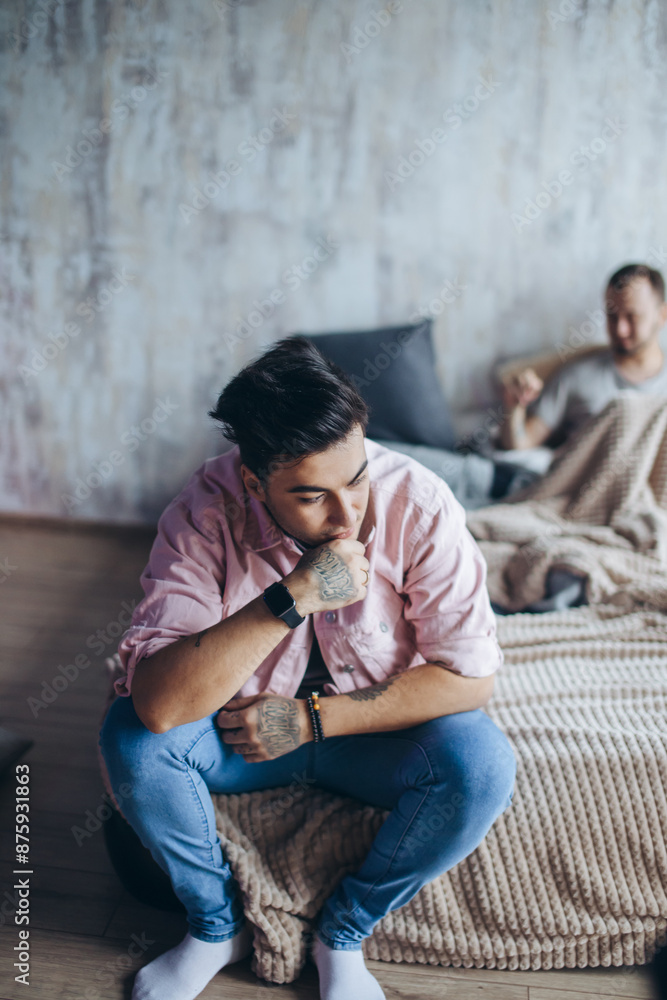 Happy gay couple having fun in an intimate atmosphere. Positive blue man laughing at his mate s joke, while sitting on bed with his frien on blurred background. Togetherness. Happy gay couple having fun in an intimate atmosphere. Positive blue man laughing at his mate s joke, while sitting on bed with his frien on blurred background. Togetherness.