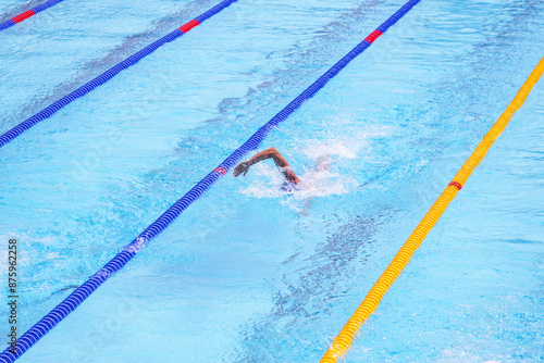 Swimmer swimming freestyle or front crawl during swimming competition in an Olympic-size swimming pool