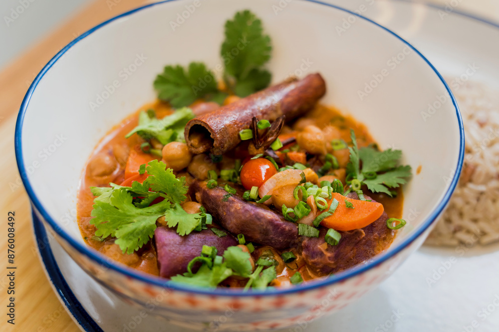 A vegetarian massaman curry in a bowl with sweet potato and many spices A vegetarian massaman curry in a bowl with sweet potato and many spices