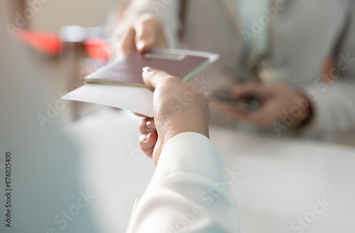 Businesswoman giving passport to airlines ground attendant or  immigration office at airport departure gate or check in counter. Travel and vacation concept photo