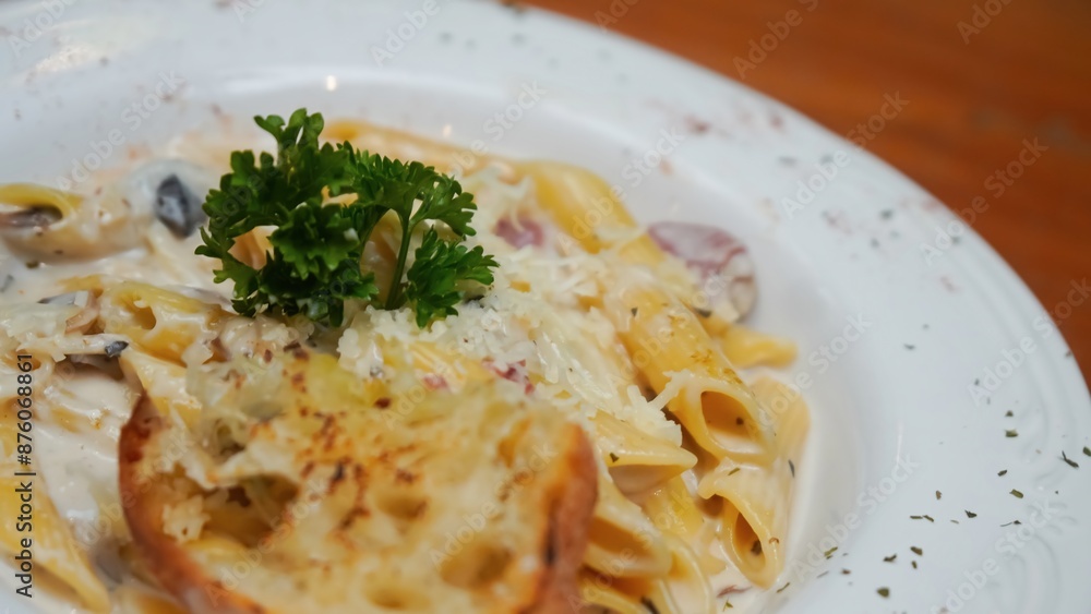 Creamy pasta with mushrooms, bacon, and a side of garlic bread. Creamy pasta with mushrooms, bacon, and a side of garlic bread.