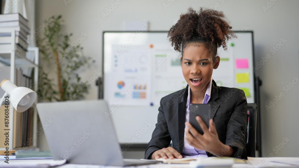 Shocked businesswoman looking at smartphone reading bad news about financial crisis Shocked businesswoman looking at smartphone reading bad news about financial crisis