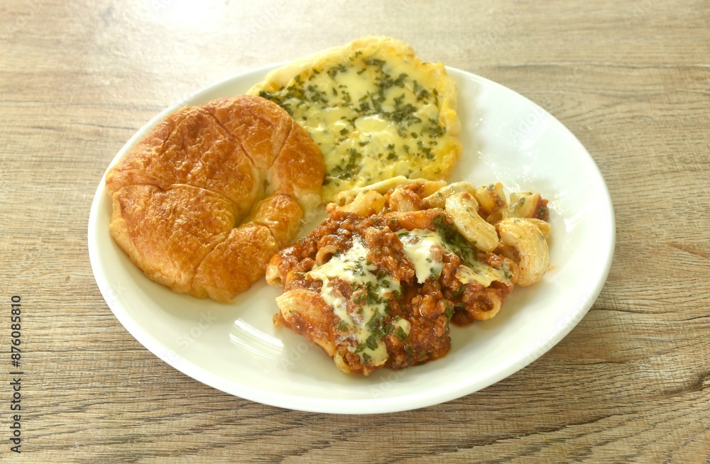 baking crispy butter croissant French bread butter garlic with macaroni dressing fried chop pork and slice tomato in ketchup sauce on plate baking crispy butter croissant French bread butter garlic with macaroni dressing fried chop pork and slice tomato in ketchup sauce on plate