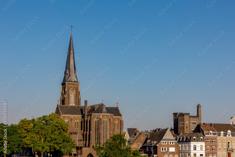 Summer cityscape of architecture traditional houses and church in Wyck district, The Sint Martinuskerk or Sint-Maartenskerk is a neo-Gothic church in the Dutch city of Maastricht, Limburg, Netherlands Summer cityscape of architecture traditional houses and church in Wyck district, The Sint Martinuskerk or Sint-Maartenskerk is a neo-Gothic church in the Dutch city of Maastricht, Limburg, Netherlands