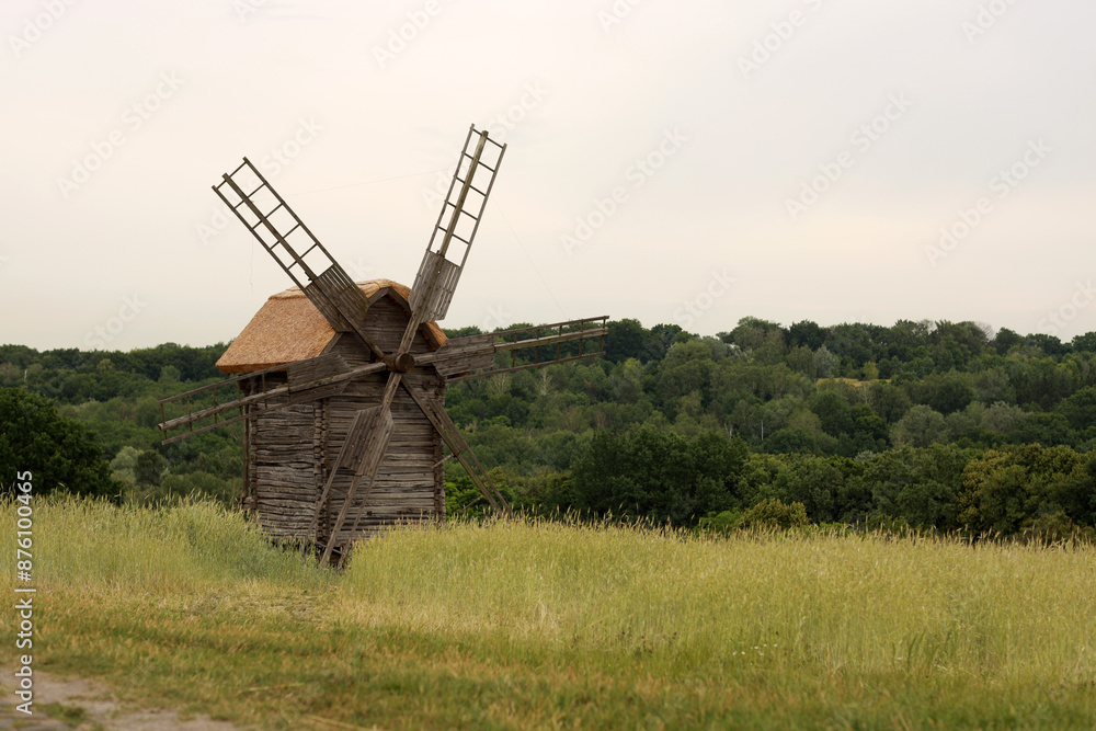 Old wooden windmill in green field Old wooden windmill in green field