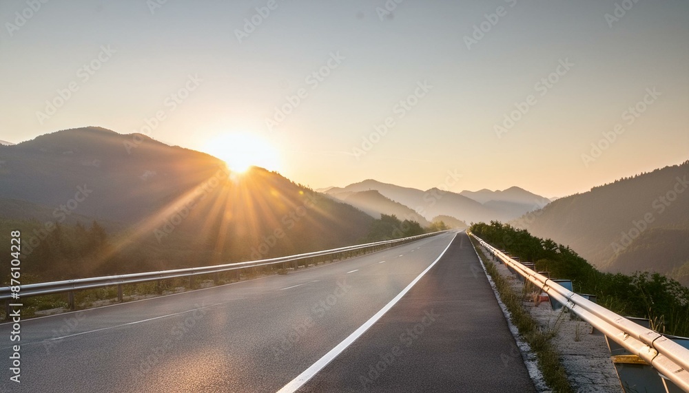 Fototapeta premium Empty highway stretching towards a vibrant sunrise over mountains. 