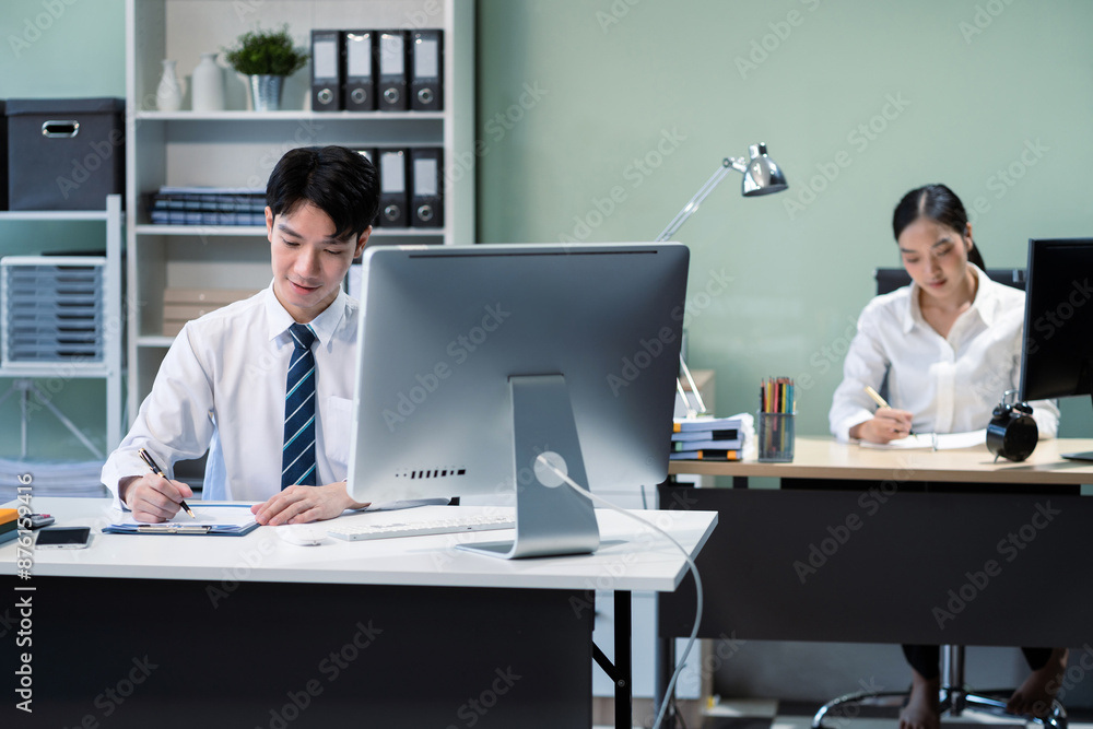 Business man and business woman sitting on desk using Tablet and laptop, working environment. Happy businessteam in casual working on computer in office. Business man and business woman sitting on desk using Tablet and laptop, working environment. Happy businessteam in casual working on computer in office.