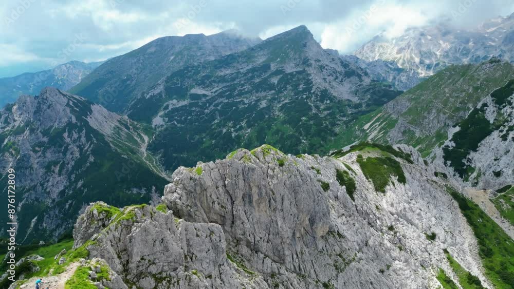 An awe-inspiring aerial view of the Slovenian Alps, featuring the majestic peaks of Viševnik, Jezerca, and Veliki Draški vrh. These stunning mountains offer breathtaking hiking trails An awe-inspiring aerial view of the Slovenian Alps, featuring the majestic peaks of Viševnik, Jezerca, and Veliki Draški vrh. These stunning mountains offer breathtaking hiking trails