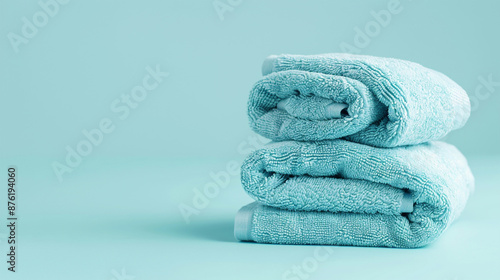 Light blue spa towels pile, bath towels in a stack on light blue peaceful background with copy space for text.