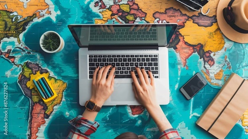 Close up shot of the person's hands typing on a laptop with a minimalist interface and bright travel website icons photo