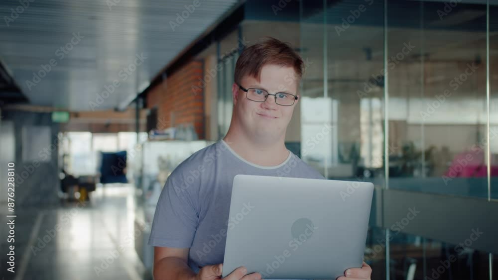 Caucasian man with down syndrome holding opened laptop Caucasian man with down syndrome holding opened laptop