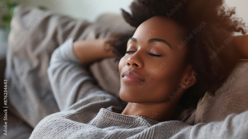 A young happy black woman lying back on a sofa relaxing A young happy black woman lying back on a sofa relaxing