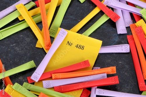 yellow winning number lies under a pile of colorful tombola tickets on the table