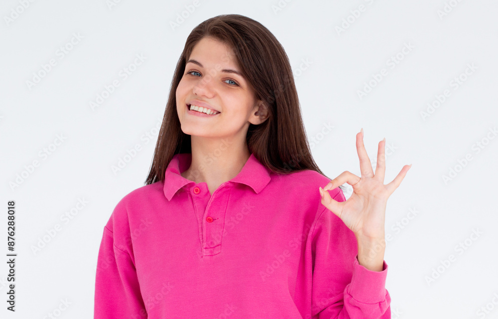 Young beautiful woman wearing pink long sleeve over isolated white background smiling positive doing ok sign with hand and fingers. Successful expression. Young beautiful woman wearing pink long sleeve over isolated white background smiling positive doing ok sign with hand and fingers. Successful expression.