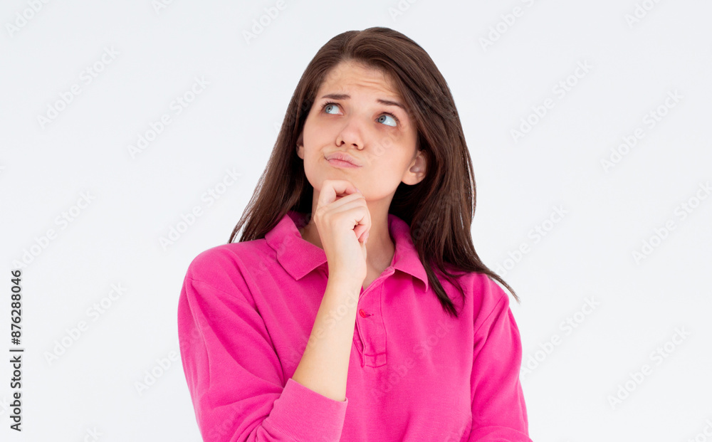 Thoughtful woman keeps hand on chin looks pensively above dressed in casual pink sweatshirt poses against white background blank copy space for your advertising content thinks about future Thoughtful woman keeps hand on chin looks pensively above dressed in casual pink sweatshirt poses against white background blank copy space for your advertising content thinks about future