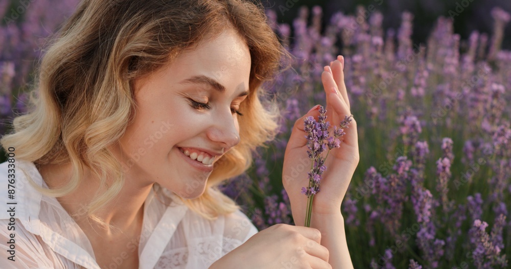 Fototapeta premium Joyful Moment: Young Woman with Lavender Flowers at Dusk