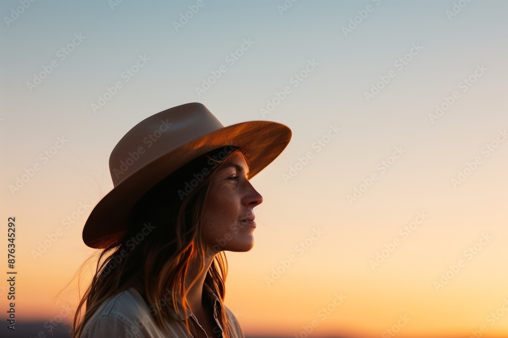 Stylish Woman in Wide-Brimmed Hat Against a Serene Sunset Sky Capturing Elegance and Tranquility Stylish Woman in Wide-Brimmed Hat Against a Serene Sunset Sky Capturing Elegance and Tranquility