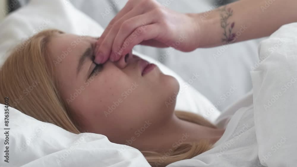 Early headache. Bad morning. Frustrating noise. Sleepy sick annoyed girl suffering from migraine covering head with pillow in bed at home. Early headache. Bad morning. Frustrating noise. Sleepy sick annoyed girl suffering from migraine covering head with pillow in bed at home.