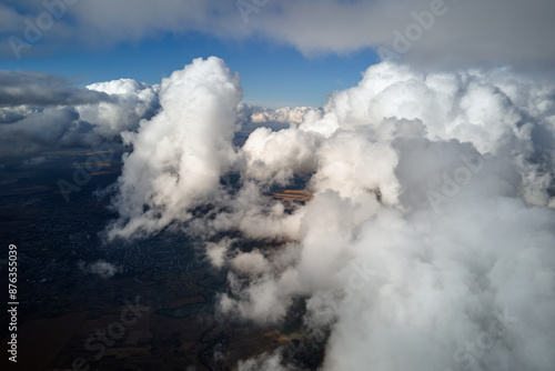 Aerial view from airplane window at high altitude of earth covered with white puffy cumulus clouds