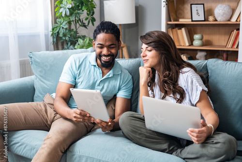 Young happy business people using digital tablet surfing the net searching for appropriate campervan for vacation travel. Business owners sold their work for adventure and camping. Freedom concept