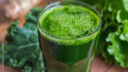 A glass of freshly squeezed green juice with cabbage and spinach leaves.