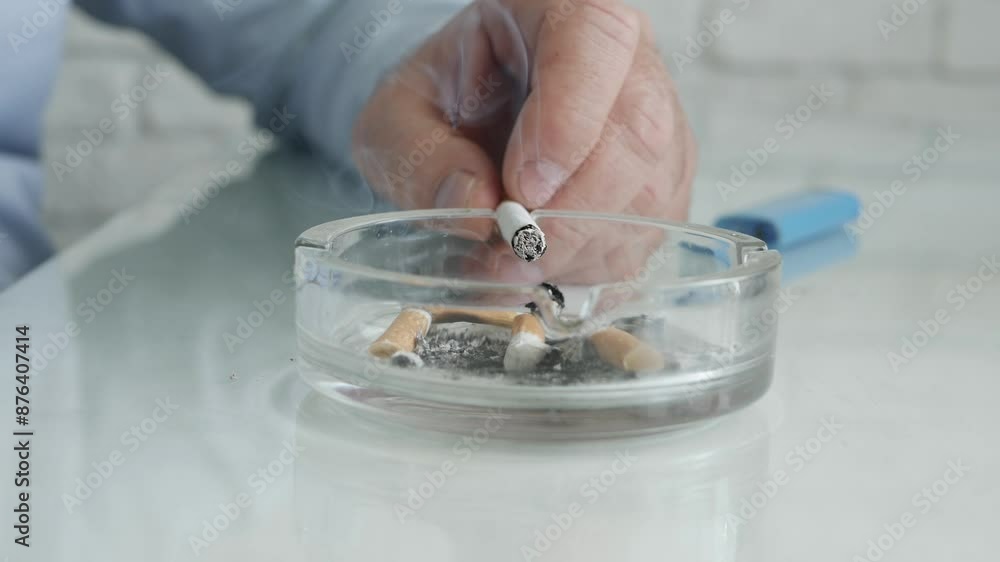 Blurred Shooting with a Smoker Who Smokes a Cigarette and Puts the Ash in an Ashtray on the Table. Man Relaxing and Smoking a Cigarette. Blurred Shooting with a Smoker Who Smokes a Cigarette and Puts the Ash in an Ashtray on the Table. Man Relaxing and Smoking a Cigarette.