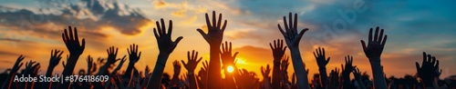 Silhouettes of Raised Hands at Sunset During an Outdoor Gathering