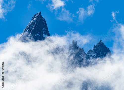 aiguille grands charmoz encadrée de nuages sur fond de ciel bleu en vallée de chamonix photo