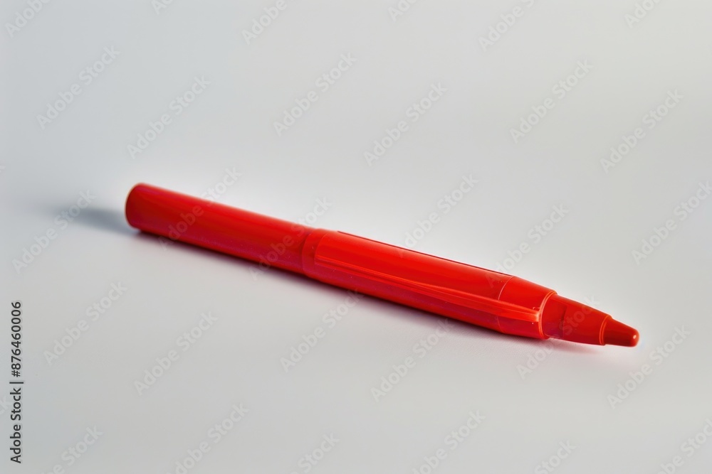 A red pen resting on a clean white surface, ready for use A red pen resting on a clean white surface, ready for use