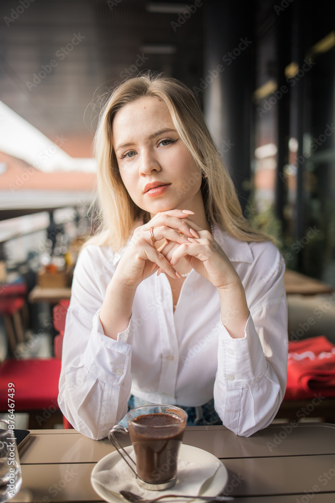 Gen z blonde woman drinks hot chocolate in summer cafe. Tasty beverage and break concept. Generation z people Gen z blonde woman drinks hot chocolate in summer cafe. Tasty beverage and break concept. Generation z people