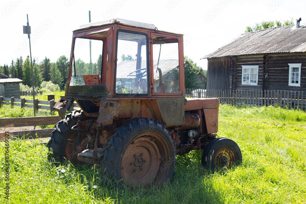 An old rusty tractor is parked in the parking lot An old rusty tractor is parked in the parking lot