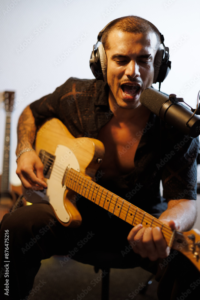 Portrait of man singing in microphone and playing electric guitar in music studio Portrait of man singing in microphone and playing electric guitar in music studio