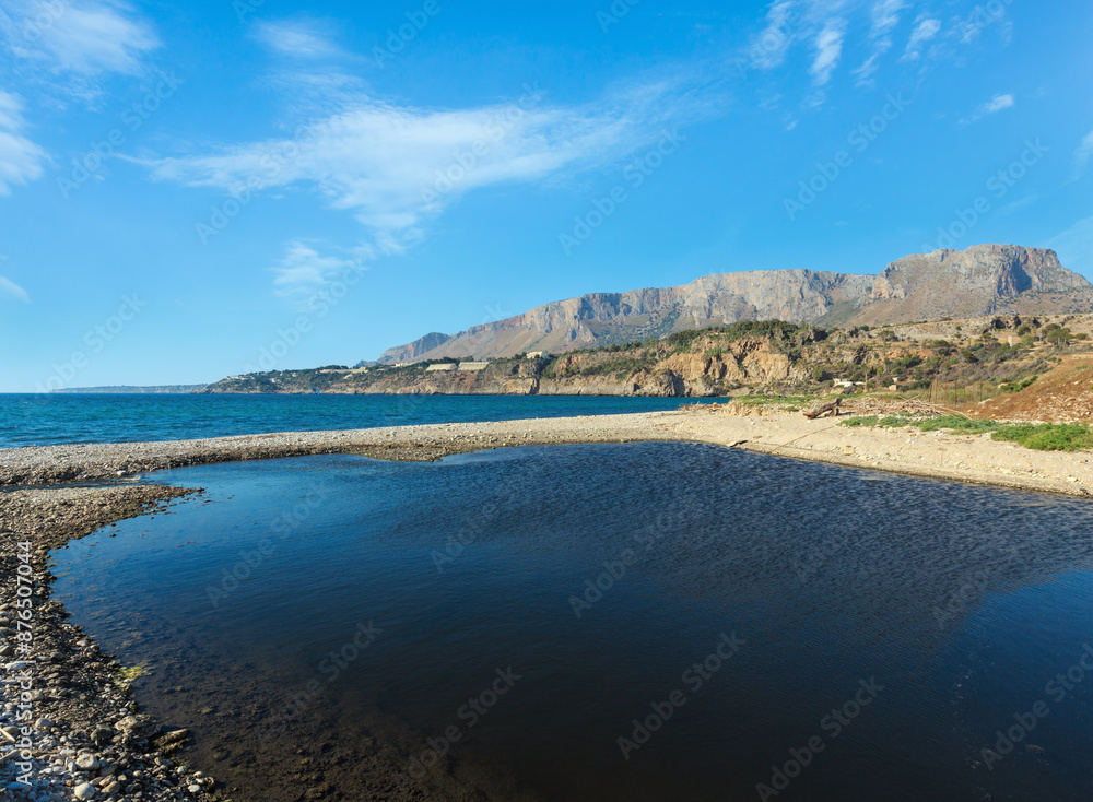 Small river flows into the sea on pebble beach Small river flows into the sea on pebble beach