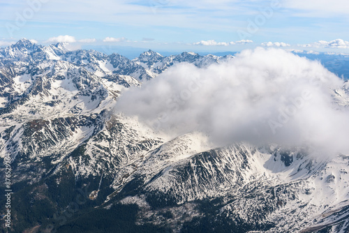 Aerial view of snow capped Tatra mountains covered by clouds