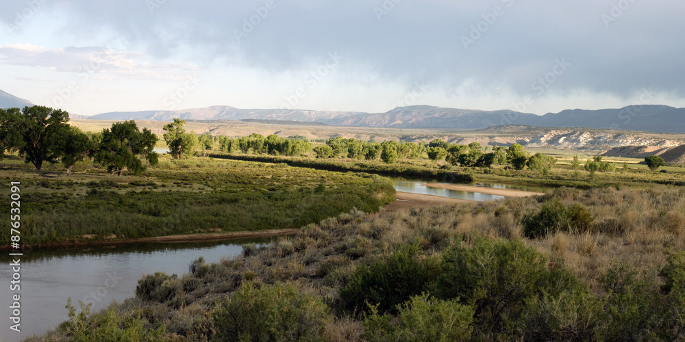Wide panorama of the Green River and riparian landscape with dry rain overhead at Browns Park National Wildlife Refuge in Colorado Wide panorama of the Green River and riparian landscape with dry rain overhead at Browns Park National Wildlife Refuge in Colorado