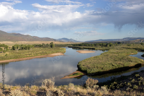 The Green River and riparian landscape with sand bars and dry rain overhead at Browns Park National Wildlife Refuge in Colorado