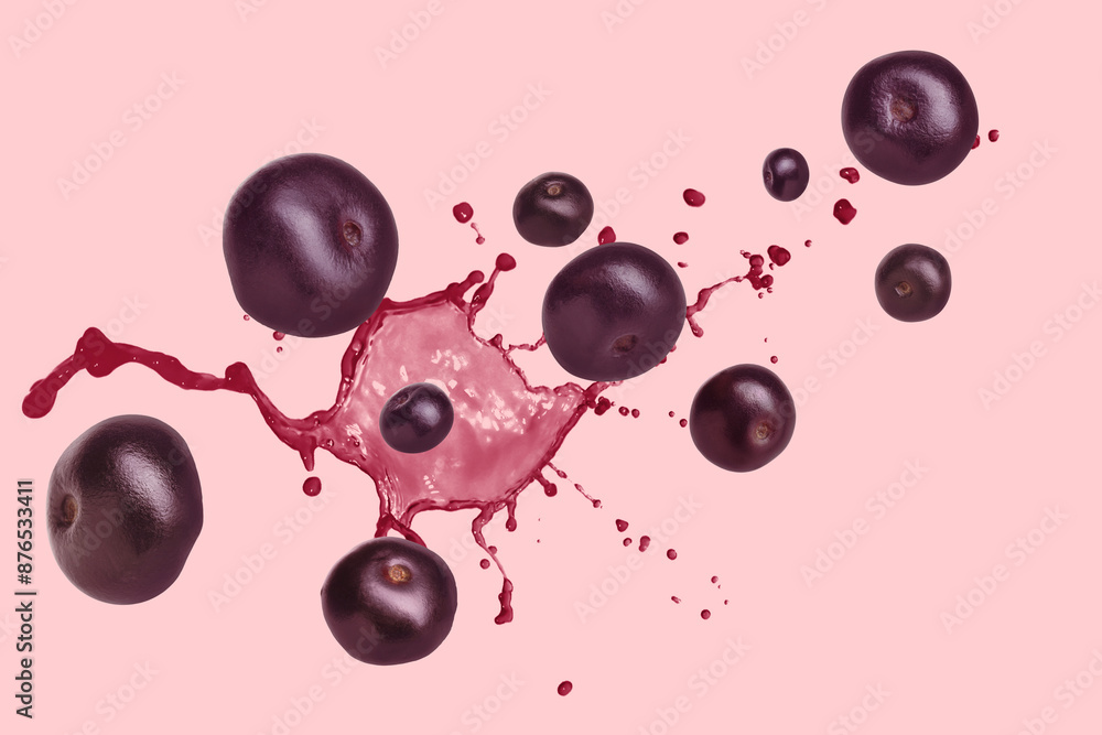 Acai berries and splash of juice in air on pink background